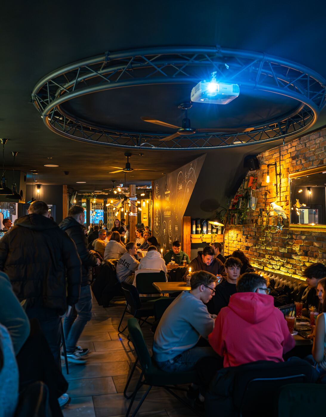 Innenbereich der Wohnzimmer Bar im Steinweg Coburg: voller Hauptraum mit Großleinwand