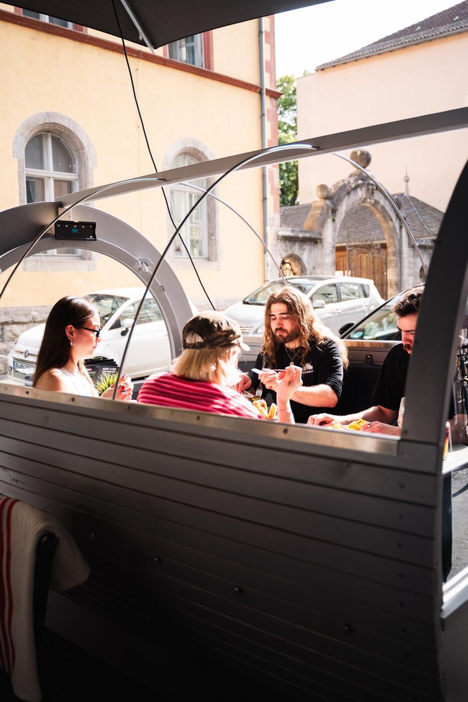 Freunde essen gemeinsam in einem Terrassenfass